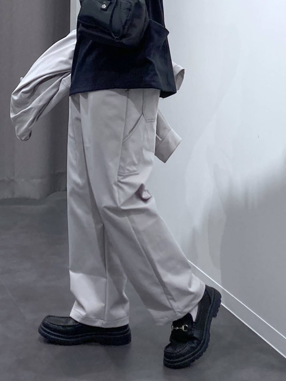 グレー系のその他パンツ、ブラック系のローファー、ブラック系のショルダーバッグを着用したメンズの冬コーディネートの9枚目の写真