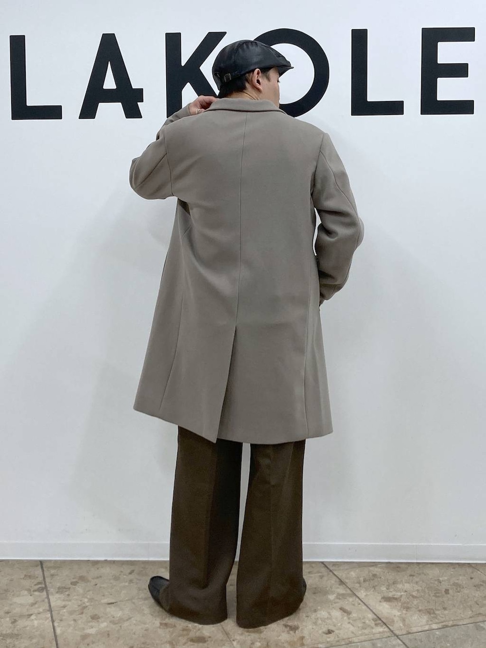 ホワイト系のチェスターコート、ブラウン系のその他パンツ、ブラック系のハンチング/ベレー帽を着用したメンズの秋コーディネートの2枚目の写真