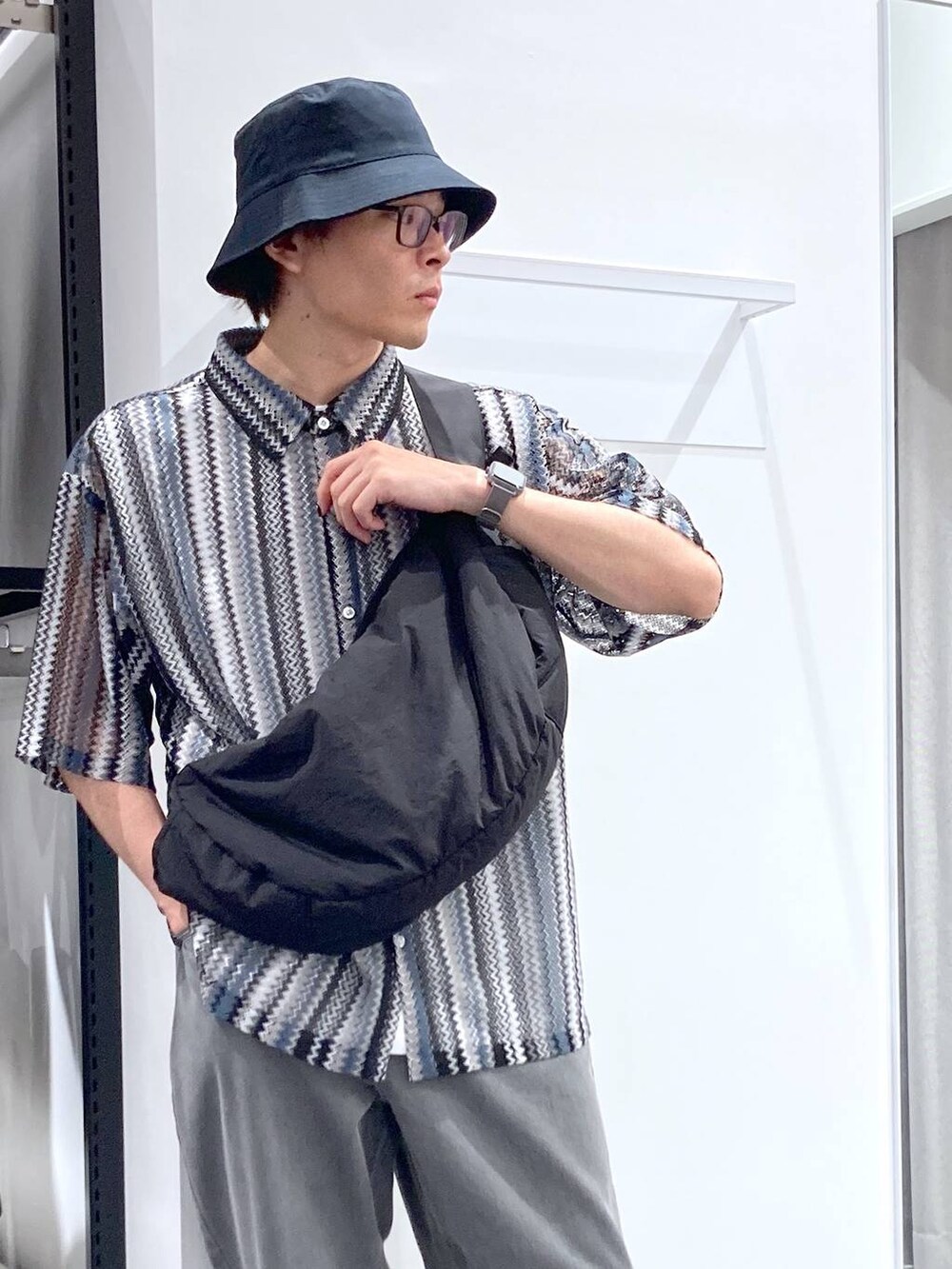 ブラック系のスニーカー、ブラック系のシャツ/ブラウス、ホワイト系のTシャツ/カットソーを着用したメンズの夏コーディネートの6枚目の写真