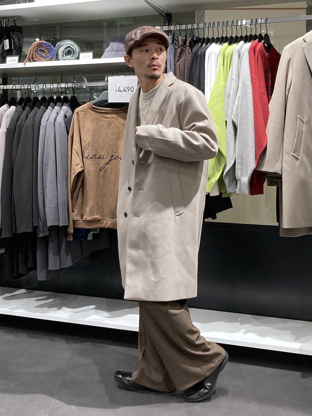 ホワイト系のチェスターコート、ベージュ系のニット/セーター、ブラウン系のその他パンツを着用したメンズの冬コーディネートの4枚目の写真