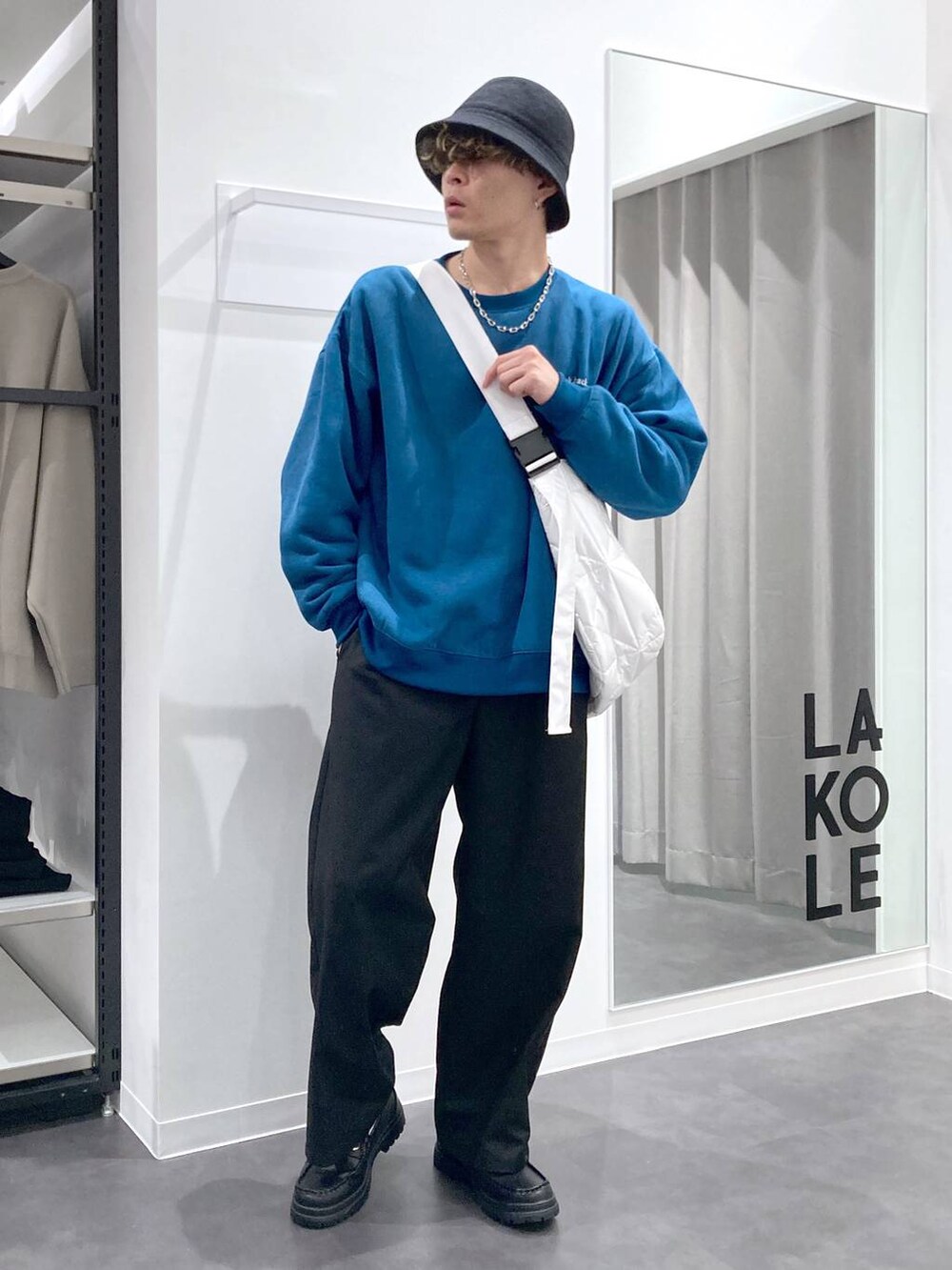 ブラック系のローファー、グリーン系のスウェット、ホワイト系のショルダーバッグを着用したメンズの冬コーディネートの5枚目の写真