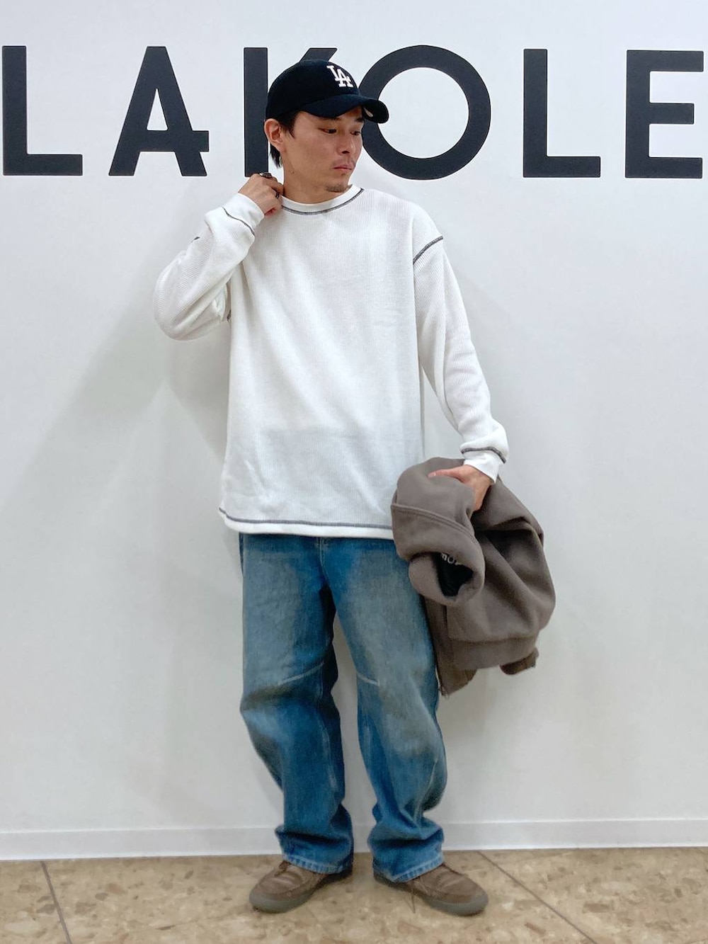 ブラウン系のブルゾン、ブルー系のデニムパンツ、ホワイト系のTシャツ/カットソーを着用したメンズの秋コーディネートの5枚目の写真