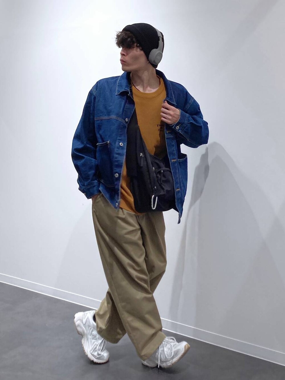 ブラック系のボディバッグ/ウエストポーチ、ホワイト系のスニーカー、ブルー系のデニムジャケットを着用したメンズの秋コーディネートの3枚目の写真