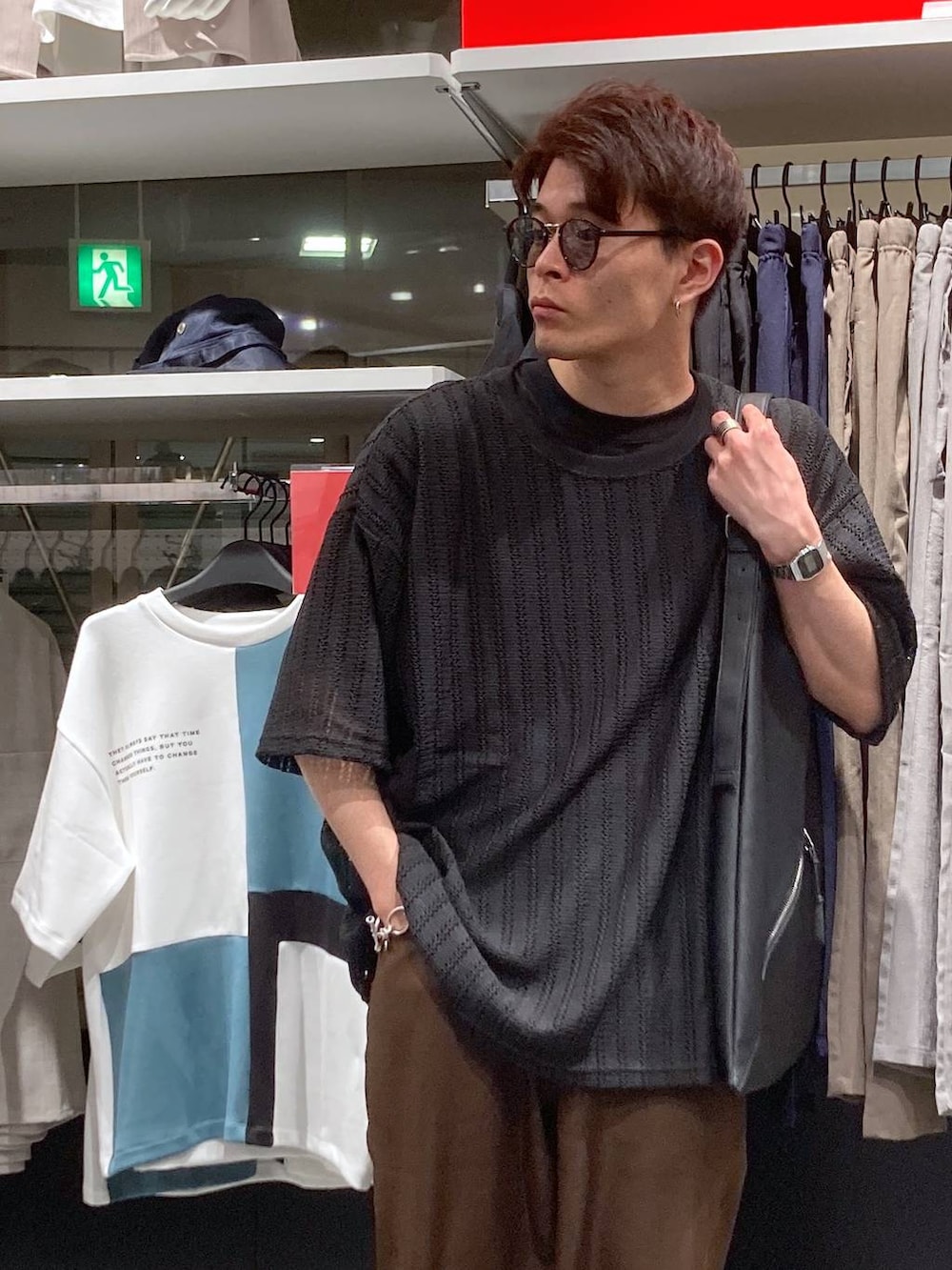 ブラック系のサンダル、ブラック系のTシャツ/カットソー、ブラック系のトートバッグを着用したメンズの夏コーディネートの7枚目の写真