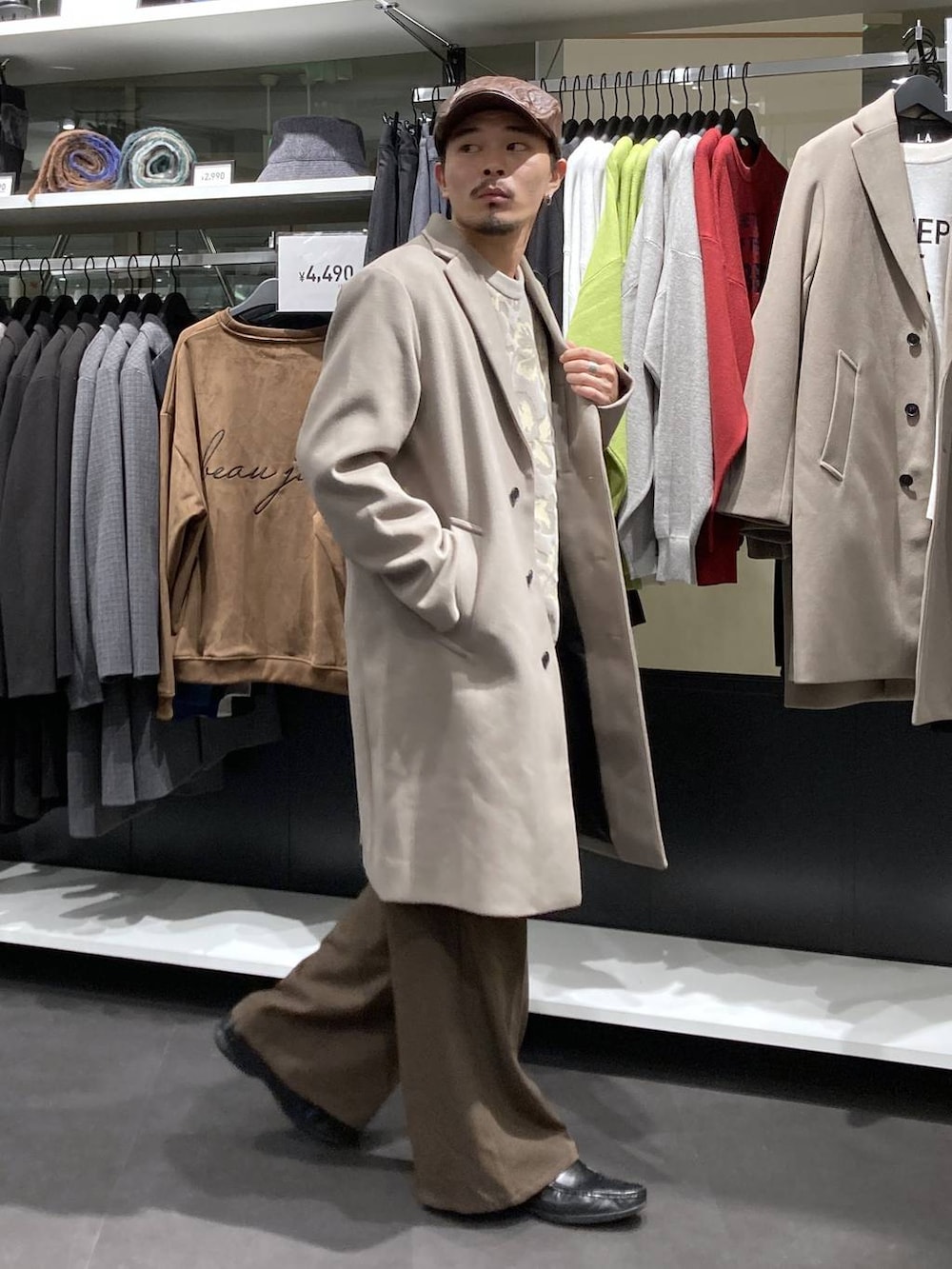 ホワイト系のチェスターコート、ベージュ系のニット/セーター、ブラウン系のその他パンツを着用したメンズの冬コーディネートの3枚目の写真