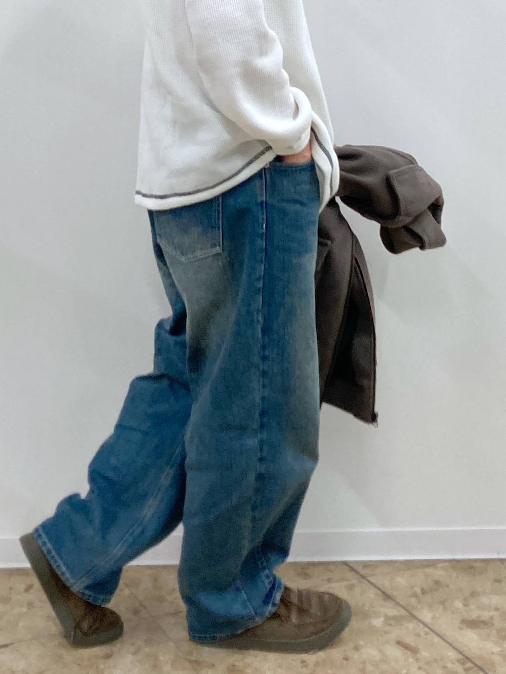 ブラウン系のブルゾン、ブルー系のデニムパンツ、ホワイト系のTシャツ/カットソーを着用したメンズの秋コーディネートの9枚目の写真