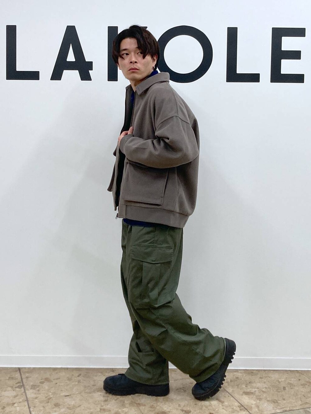 グリーン系のカーゴパンツ、ブラウン系のブルゾン、ブルー系のデニムジャケットを着用したメンズの冬コーディネートの3枚目の写真