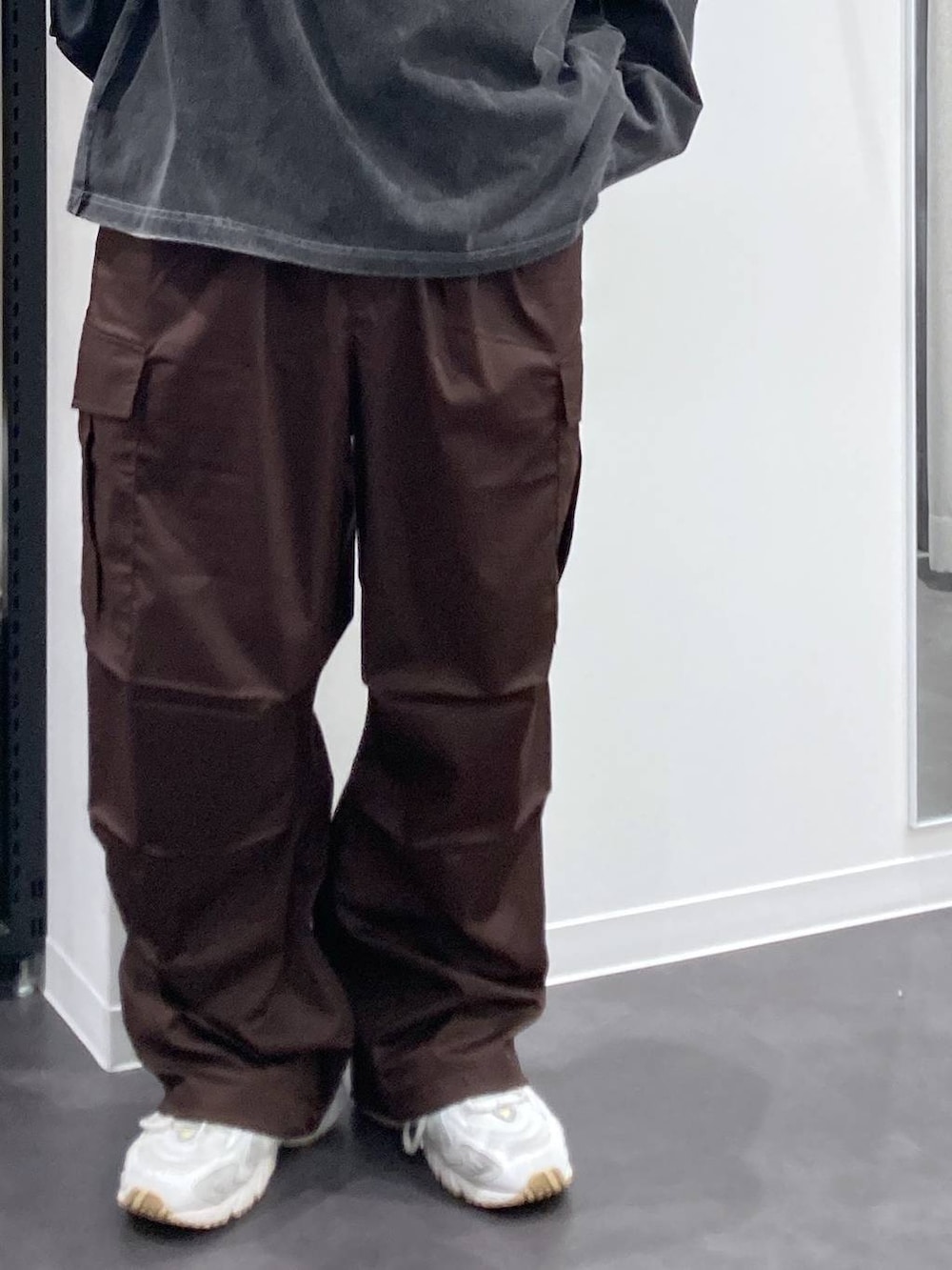 ホワイト系のTシャツ/カットソー、ブラウン系のカーゴパンツ、ブラック系のバックパック/リュックを着用したメンズの夏コーディネートの7枚目の写真