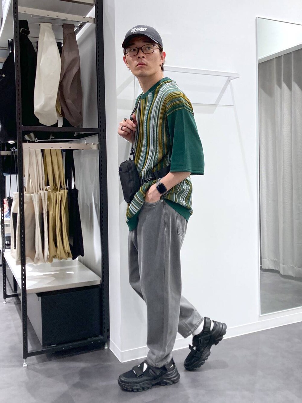 ブラック系のスニーカー、ブラック系のボディバッグ/ウエストポーチ、ホワイト系のTシャツ/カットソーを着用したメンズの夏コーディネートの3枚目の写真