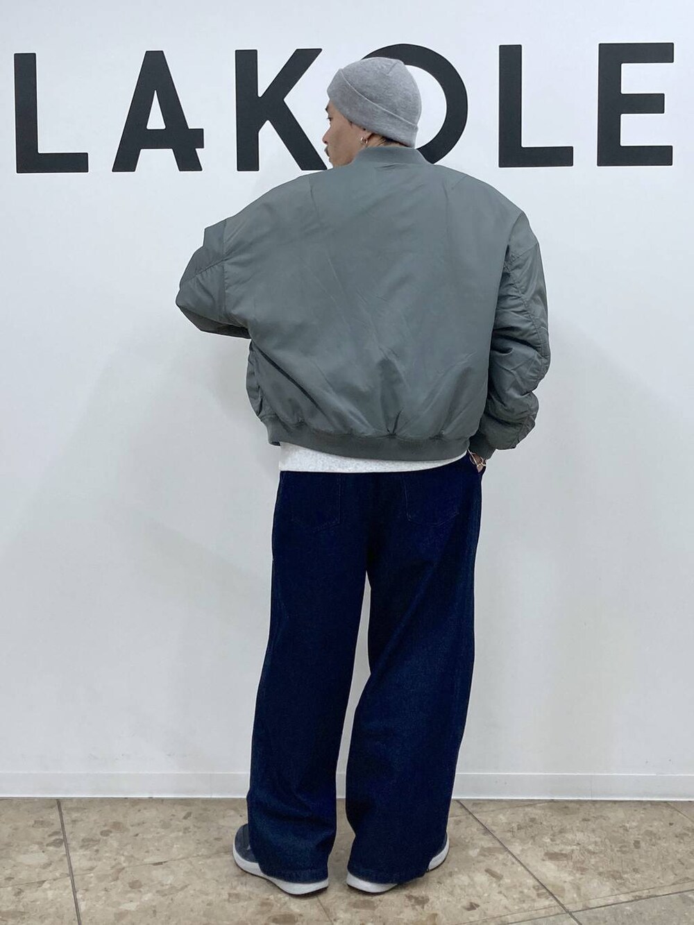 ブルー系のスニーカー、グリーン系のブルゾン、ブルー系のデニムパンツを着用したメンズの冬コーディネートの2枚目の写真