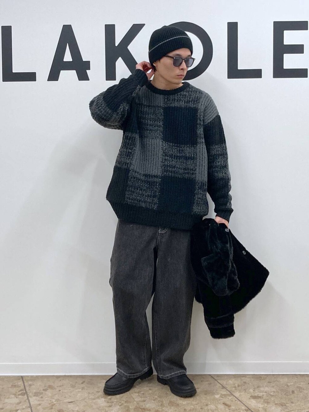 ブラック系のニット/セーター、グレー系のデニムパンツ、ブラック系のローファーを着用したメンズの冬コーディネートの5枚目の写真