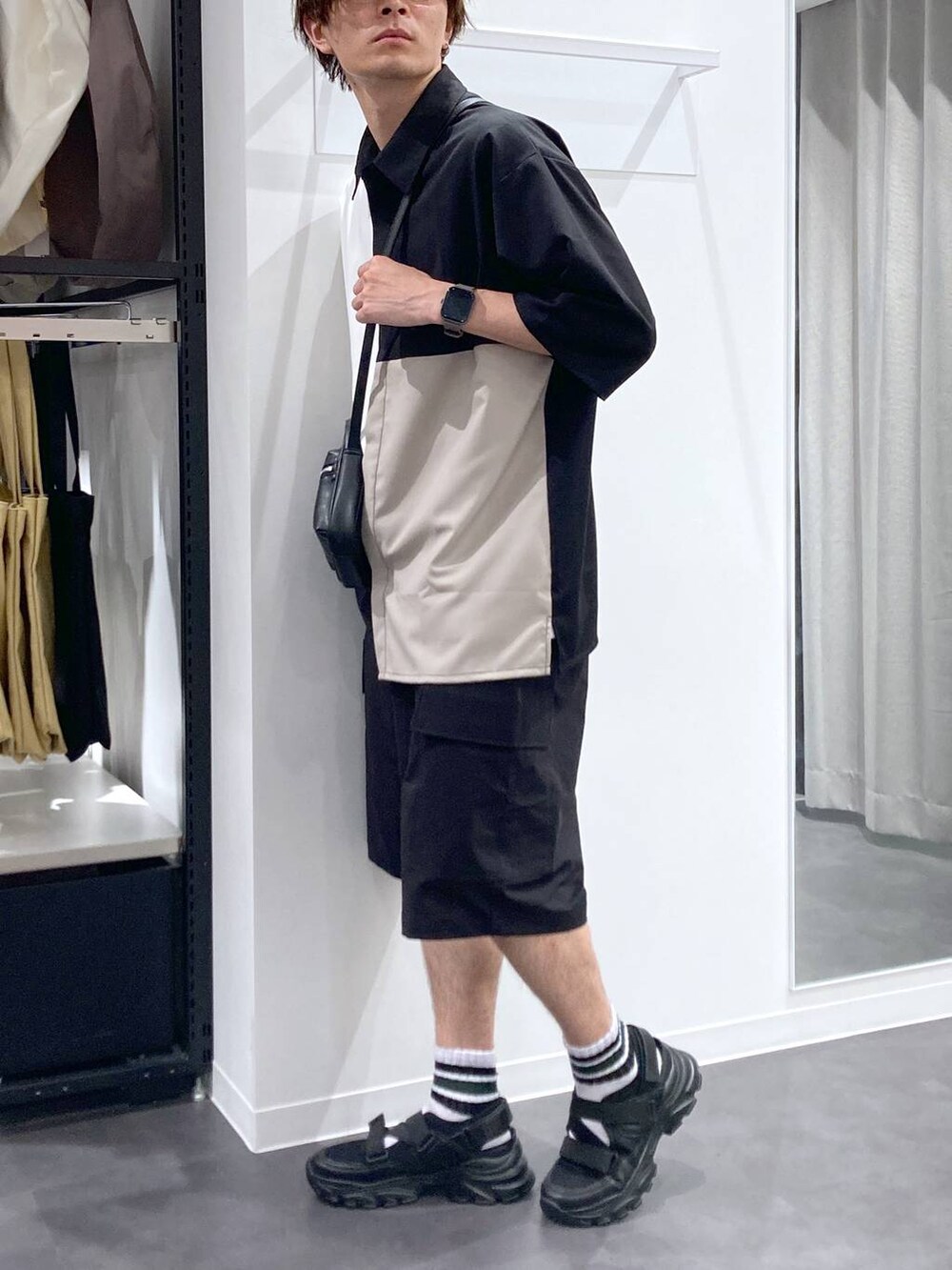 ブラック系のスニーカー、ホワイト系のTシャツ/カットソー、ブラック系のショルダーバッグを着用したメンズの夏コーディネートの3枚目の写真