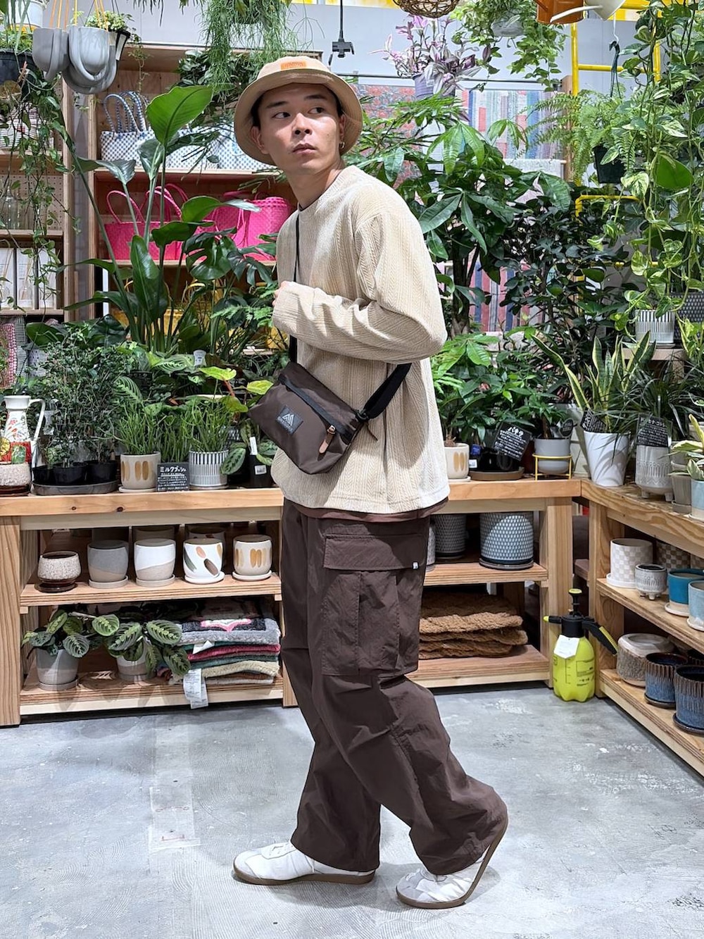 ベージュ系のTシャツ/カットソー、ブラウン系のカーゴパンツ、ベージュ系のハットを着用したメンズの秋コーディネートの3枚目の写真