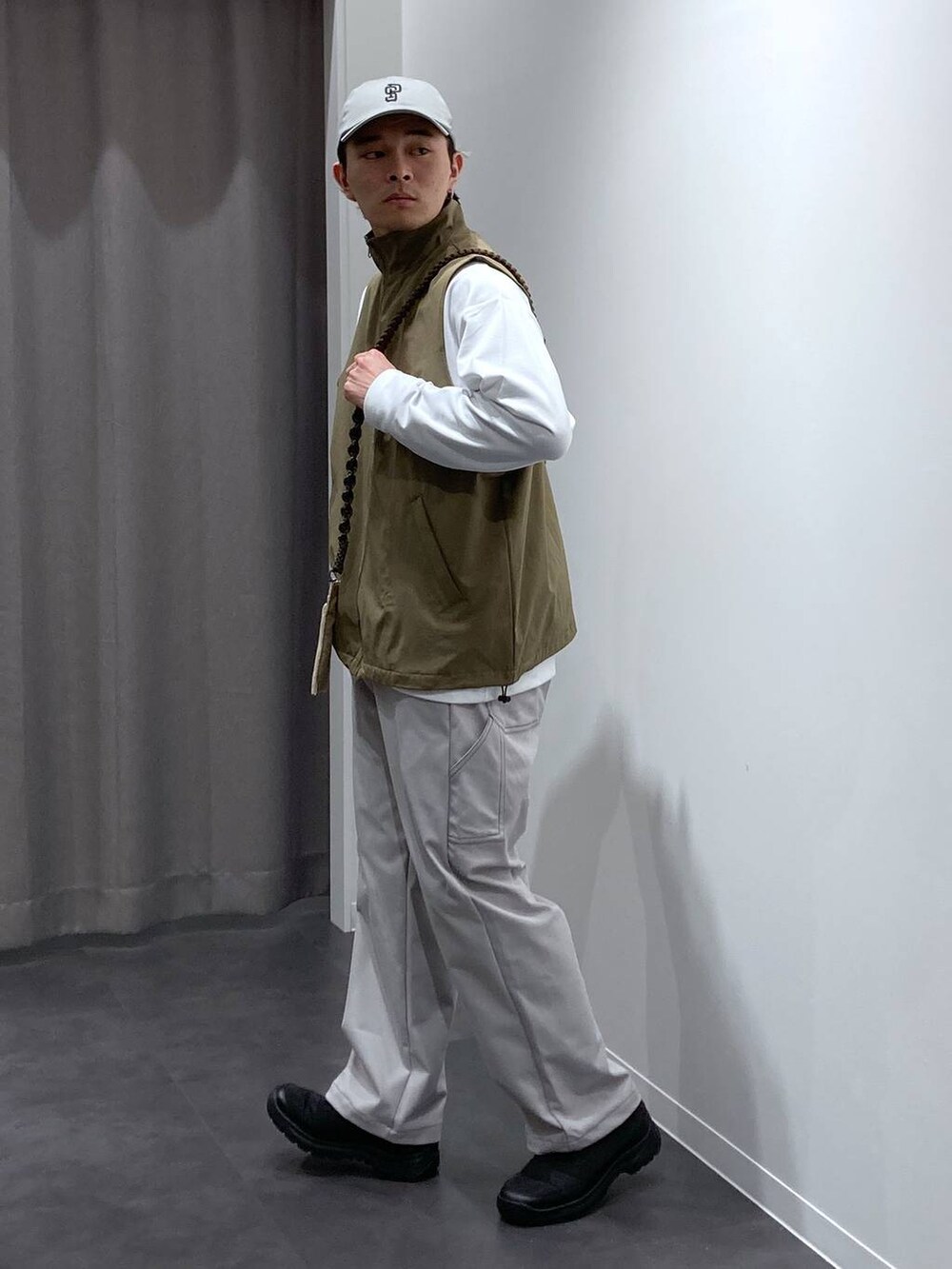 ベージュ系のベスト、グレー系のその他パンツ、ブラック系のスリッポンを着用したメンズの冬コーディネートの4枚目の写真