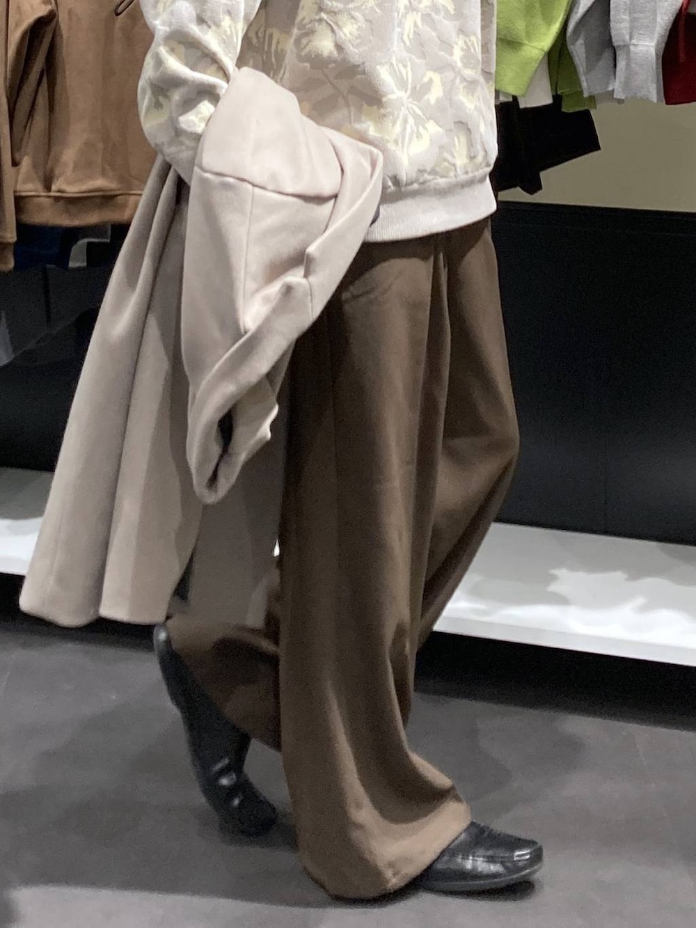 ホワイト系のチェスターコート、ベージュ系のニット/セーター、ブラウン系のその他パンツを着用したメンズの冬コーディネートの9枚目の写真