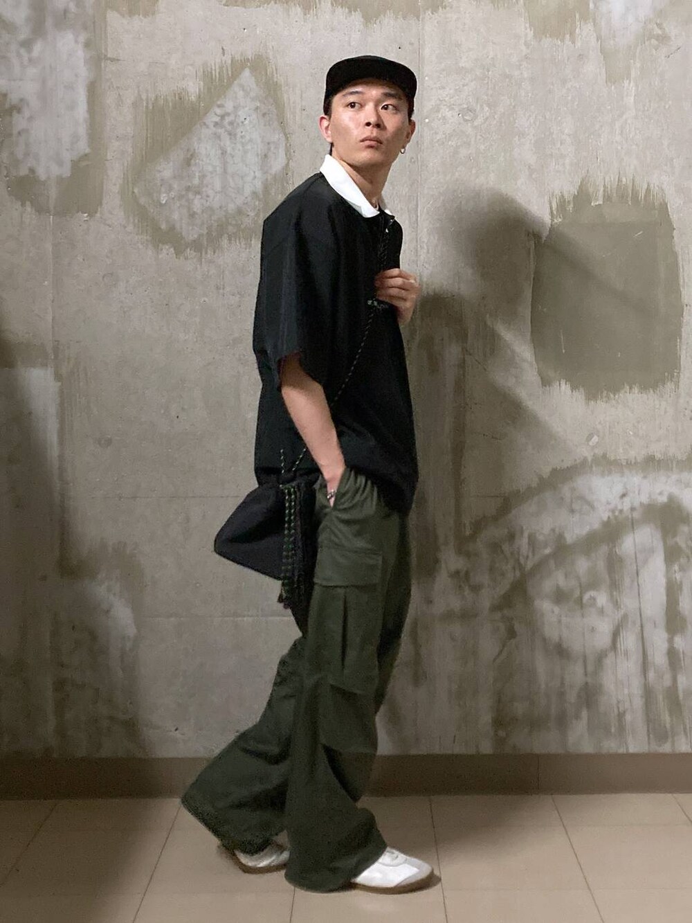 ホワイト系のTシャツ/カットソー、グリーン系のカーゴパンツ、ブラック系のショルダーバッグを着用したメンズの夏コーディネートの3枚目の写真