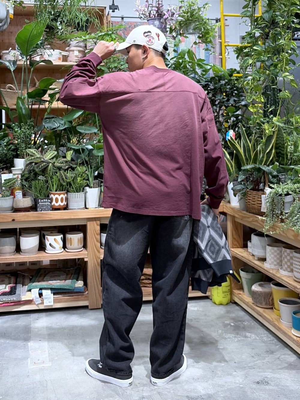 ブラック系のデニムパンツ、レッド系のTシャツ/カットソー、グレー系のカーディガン/ボレロを着用したメンズの秋コーディネートの6枚目の写真