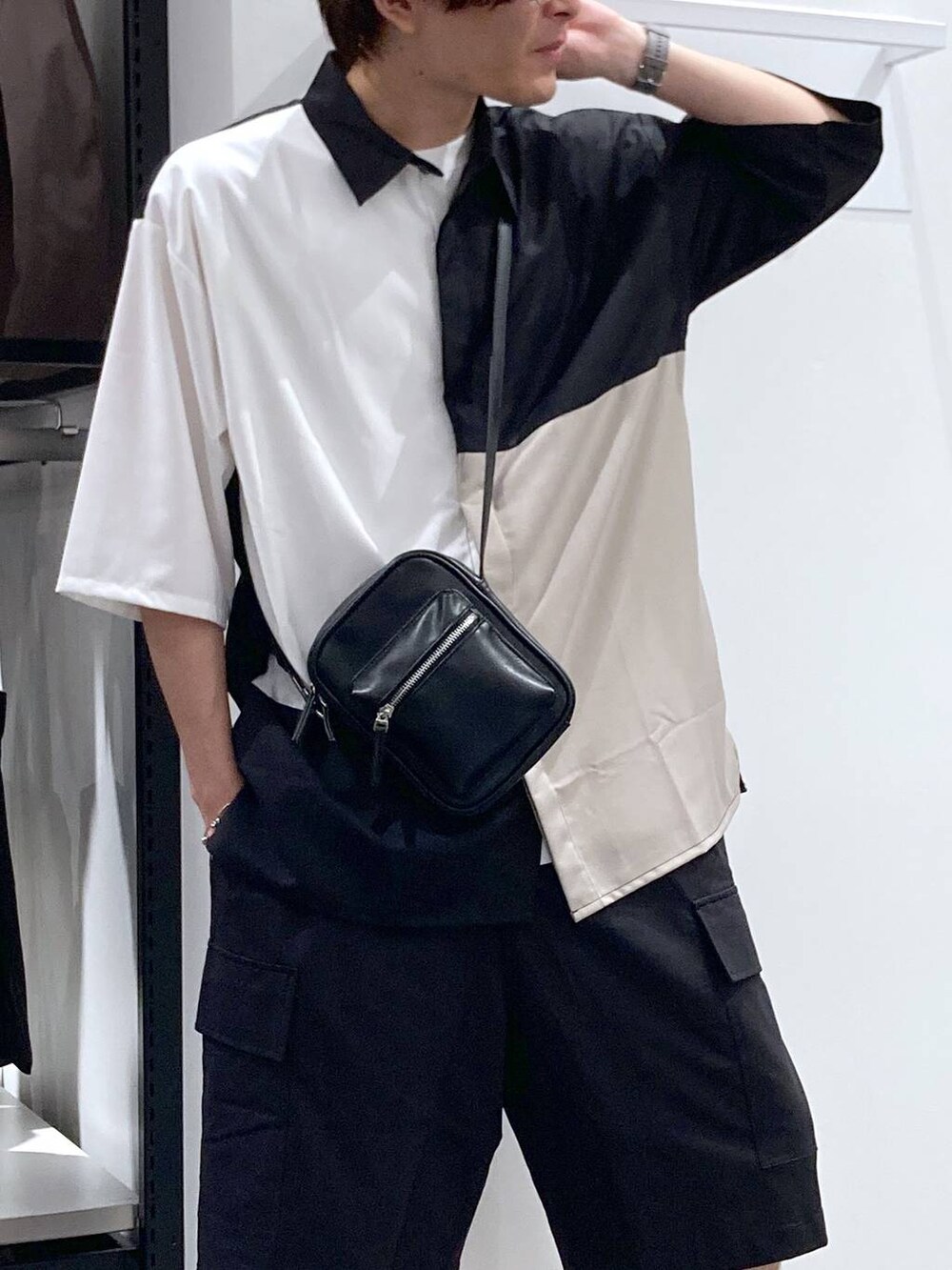 ブラック系のスニーカー、ホワイト系のTシャツ/カットソー、ブラック系のショルダーバッグを着用したメンズの夏コーディネートの6枚目の写真