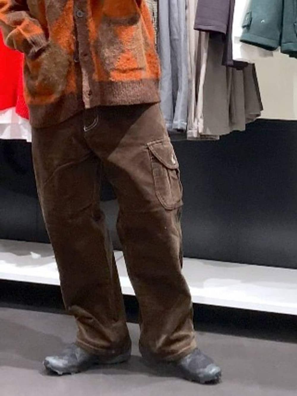 ブラウン系のその他パンツ、ブラウン系のカーディガン/ボレロ、オレンジ系のニットキャップ/ビーニーを着用したメンズの冬コーディネートの8枚目の写真