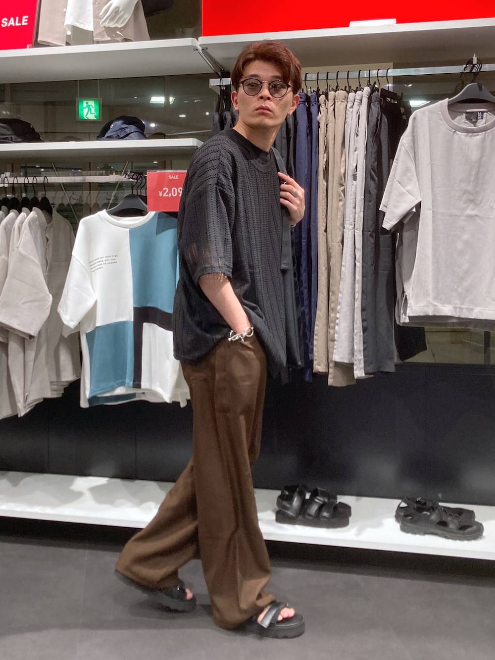 ブラック系のサンダル、ブラック系のTシャツ/カットソー、ブラック系のトートバッグを着用したメンズの夏コーディネートの4枚目の写真