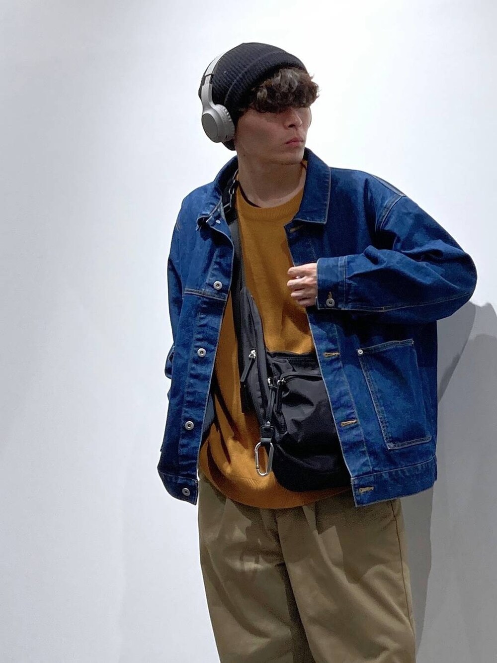 ブラック系のボディバッグ/ウエストポーチ、ホワイト系のスニーカー、ブルー系のデニムジャケットを着用したメンズの秋コーディネートの5枚目の写真