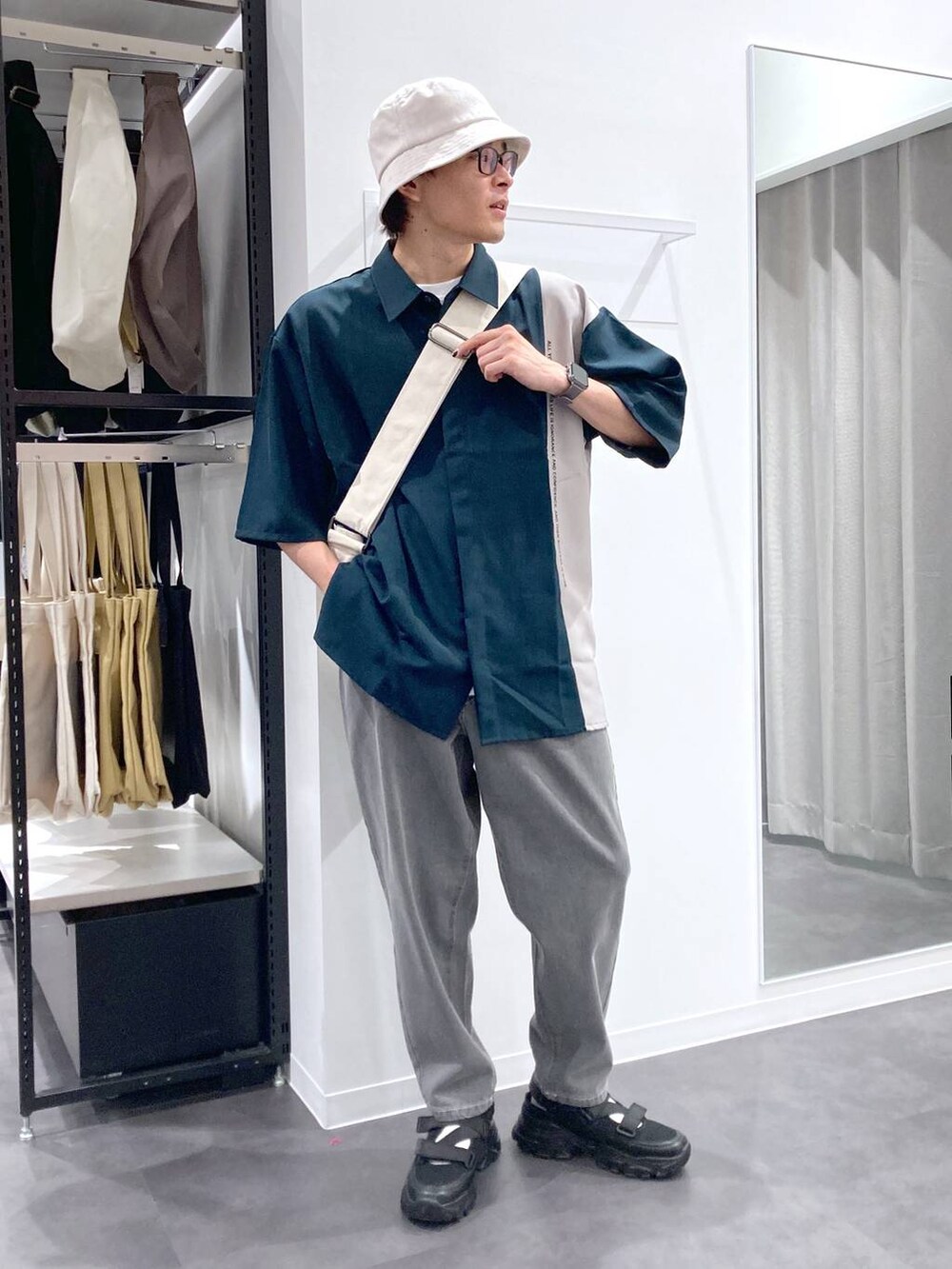 ブラック系のスニーカー、ベージュ系のショルダーバッグ、グリーン系のシャツ/ブラウスを着用したメンズの夏コーディネートの5枚目の写真