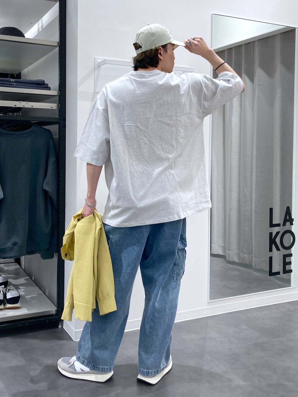 グレー系のTシャツ/カットソー、グレー系のスニーカー、ブルー系のデニムパンツを着用したメンズの春コーディネートの5枚目の写真