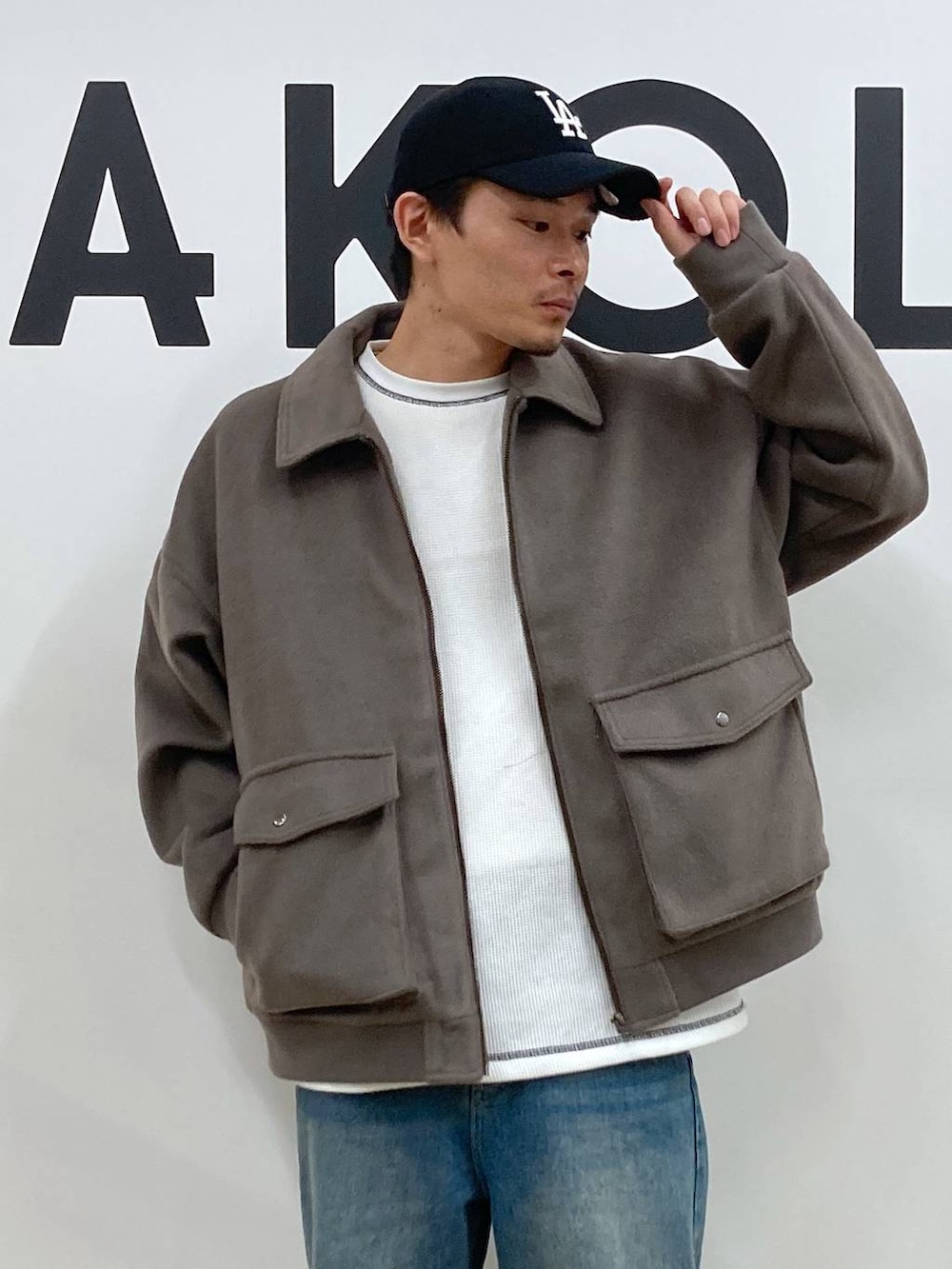 ブラウン系のブルゾン、ブルー系のデニムパンツ、ホワイト系のTシャツ/カットソーを着用したメンズの秋コーディネートの8枚目の写真