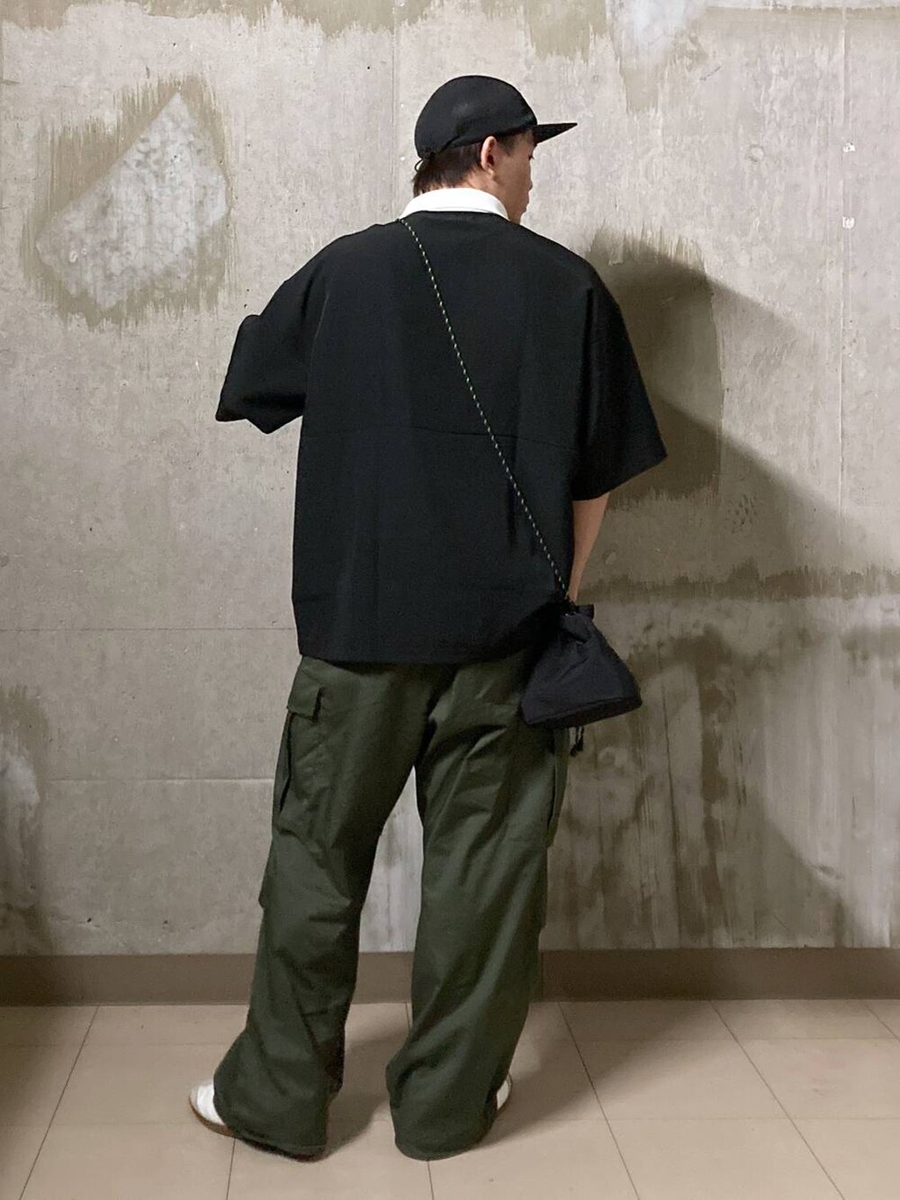 ホワイト系のTシャツ/カットソー、グリーン系のカーゴパンツ、ブラック系のショルダーバッグを着用したメンズの夏コーディネートの2枚目の写真
