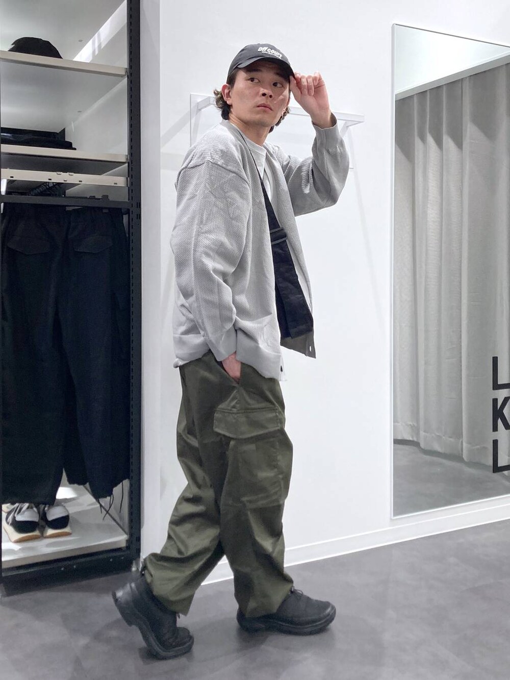 グレー系のTシャツ/カットソー、ブラック系のスリッポン、グリーン系のカーゴパンツを着用したメンズの春コーディネートの3枚目の写真