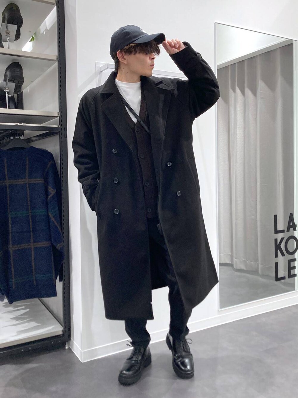 ブラック系のトレンチコート、グレー系のTシャツ/カットソー、ホワイト系のスウェットを着用したメンズの冬コーディネートの8枚目の写真