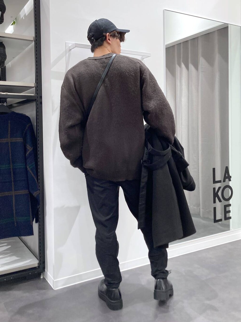 ブラック系のトレンチコート、グレー系のTシャツ/カットソー、ホワイト系のスウェットを着用したメンズの冬コーディネートの6枚目の写真