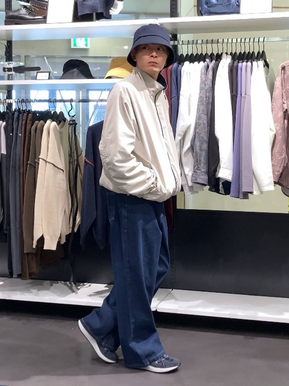 ブルー系のスニーカー、ブルー系のハットを着用したメンズの秋コーディネートの4枚目の写真