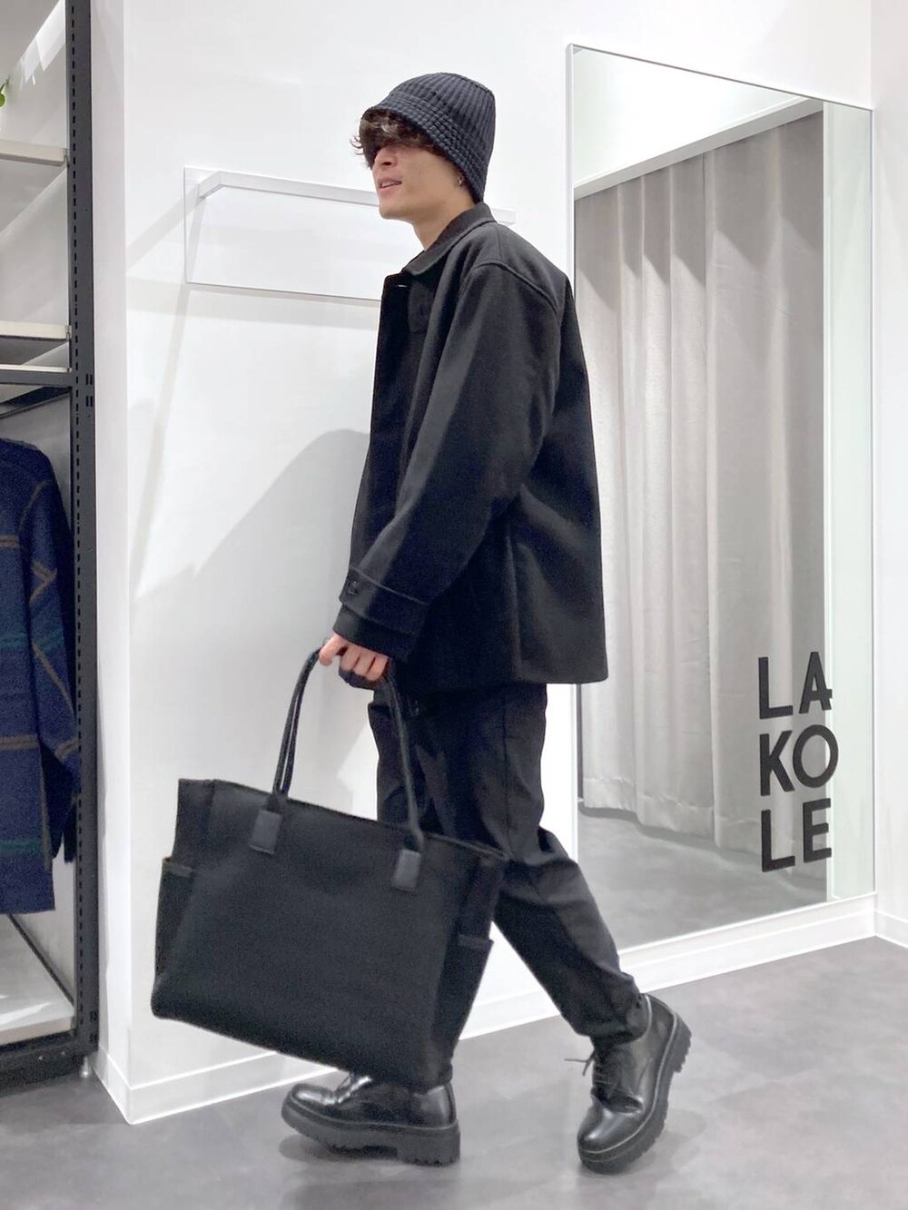 ブラック系のステンカラーコート、ブラック系のトートバッグ、ブラック系のドレスシューズを着用したメンズの冬コーディネートの8枚目の写真