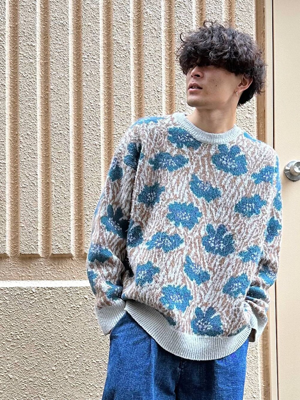 ブルー系のニット/セーター、ブルー系のデニムパンツを着用したメンズの秋コーディネートの3枚目の写真