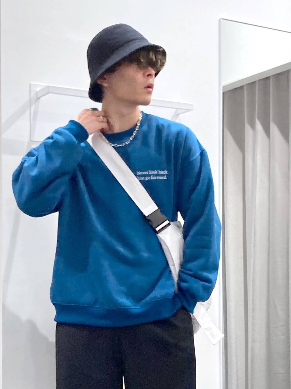 ブラック系のローファー、グリーン系のスウェット、ホワイト系のショルダーバッグを着用したメンズの冬コーディネートの4枚目の写真