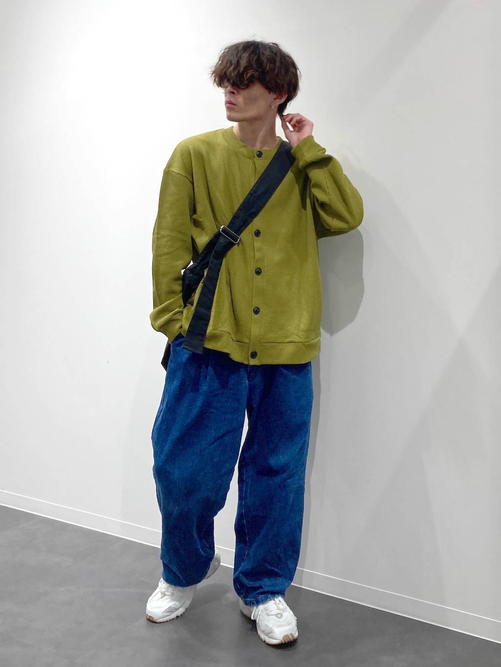 ホワイト系のスニーカー、イエロー系のTシャツ/カットソー、ブルー系のデニムパンツを着用したメンズの秋コーディネートの8枚目の写真