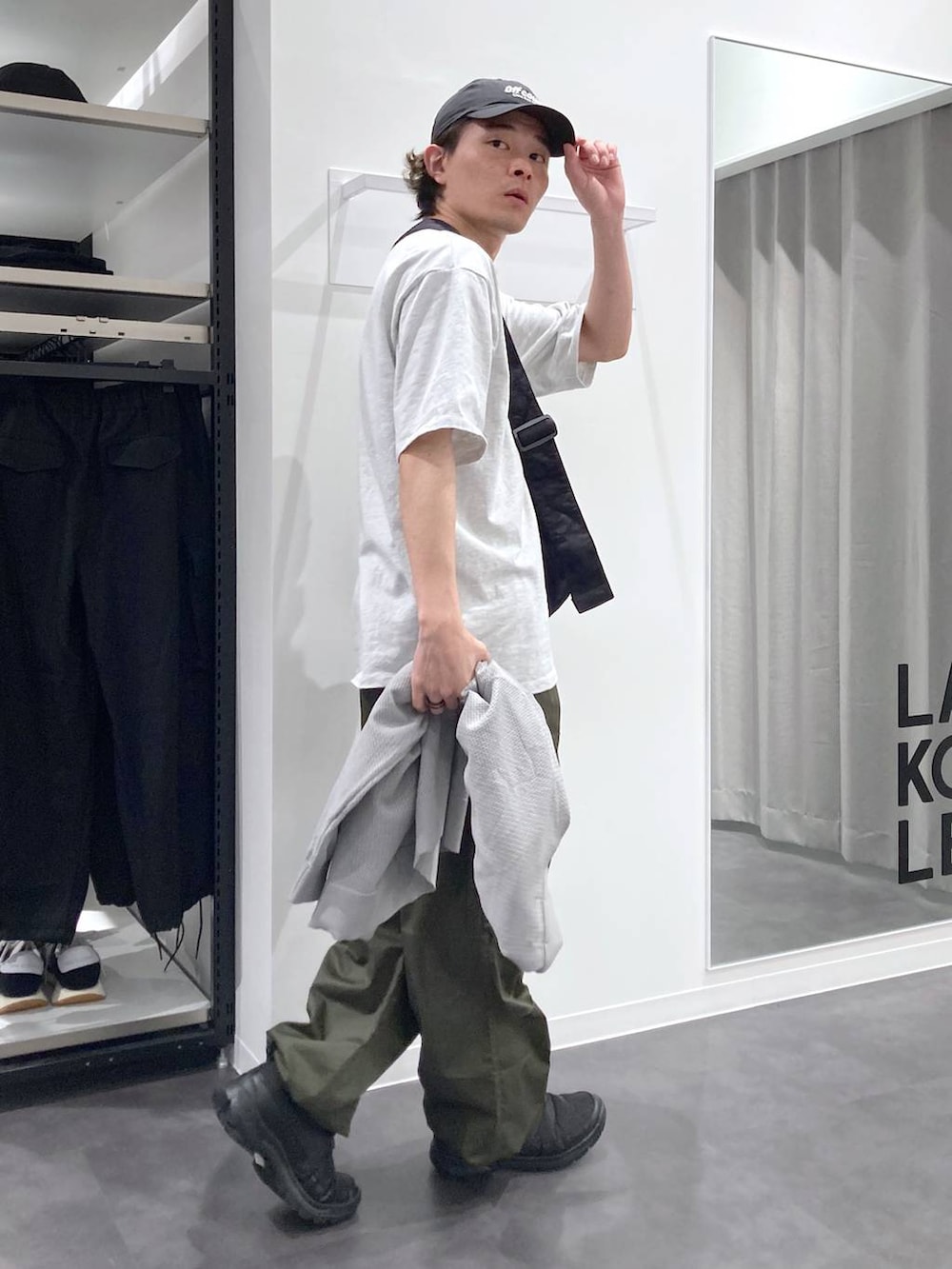 グレー系のTシャツ/カットソー、ブラック系のスリッポン、グリーン系のカーゴパンツを着用したメンズの春コーディネートの6枚目の写真