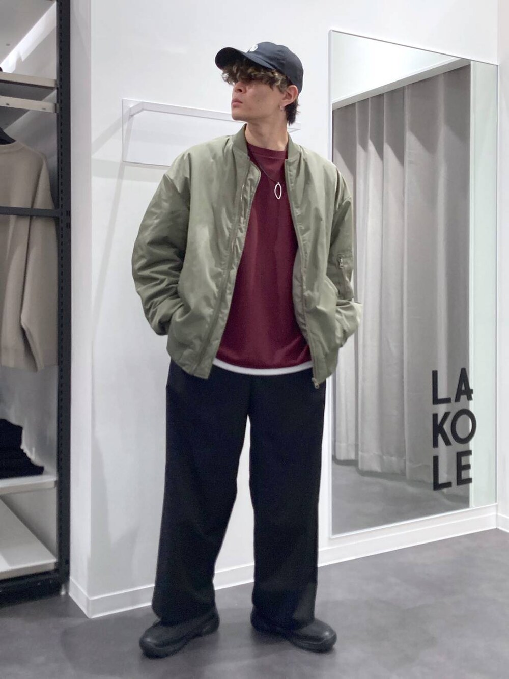 グリーン系のMA-1、レッド系のTシャツ/カットソー、ブラック系のスリッポンを着用したメンズの冬コーディネートの7枚目の写真