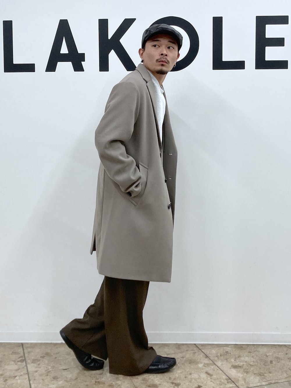 ホワイト系のチェスターコート、ブラウン系のその他パンツ、ブラック系のハンチング/ベレー帽を着用したメンズの秋コーディネートの4枚目の写真