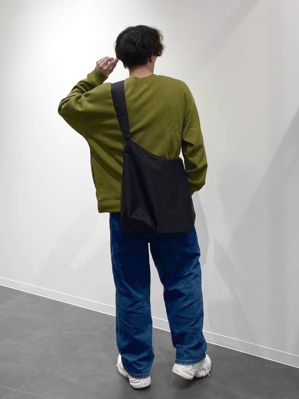 ホワイト系のスニーカー、イエロー系のTシャツ/カットソー、ブルー系のデニムパンツを着用したメンズの秋コーディネートの2枚目の写真