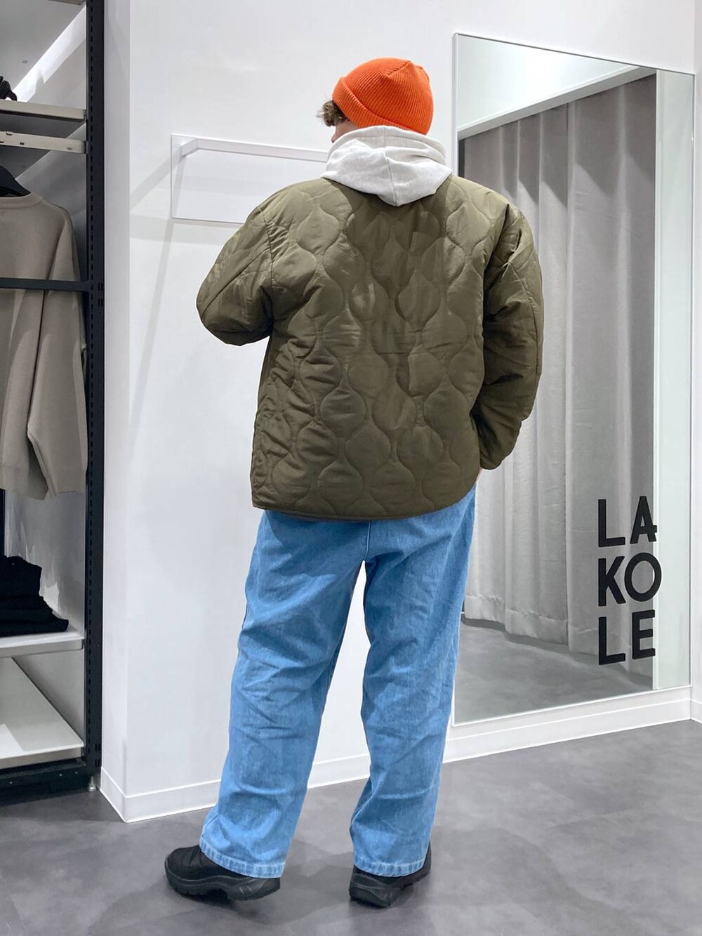 ホワイト系のパーカー、ブラック系のショルダーバッグ、グリーン系のブルゾンを着用したメンズの冬コーディネートの2枚目の写真