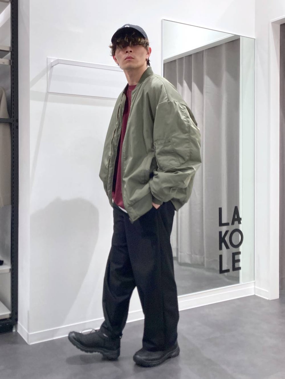 グリーン系のMA-1、レッド系のTシャツ/カットソー、ブラック系のスリッポンを着用したメンズの冬コーディネートの3枚目の写真