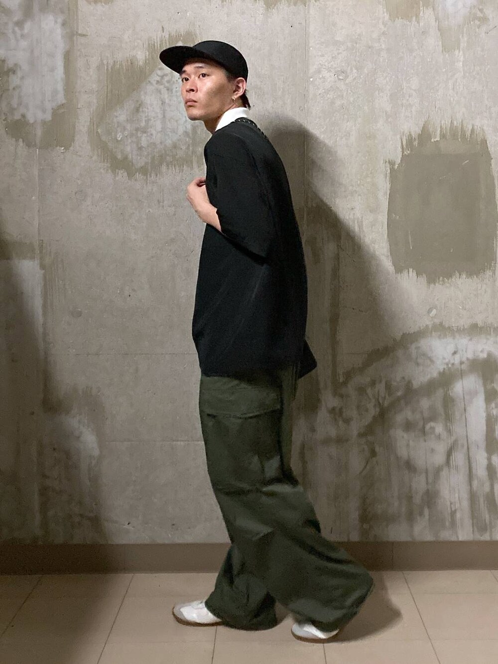 ホワイト系のTシャツ/カットソー、グリーン系のカーゴパンツ、ブラック系のショルダーバッグを着用したメンズの夏コーディネートの4枚目の写真