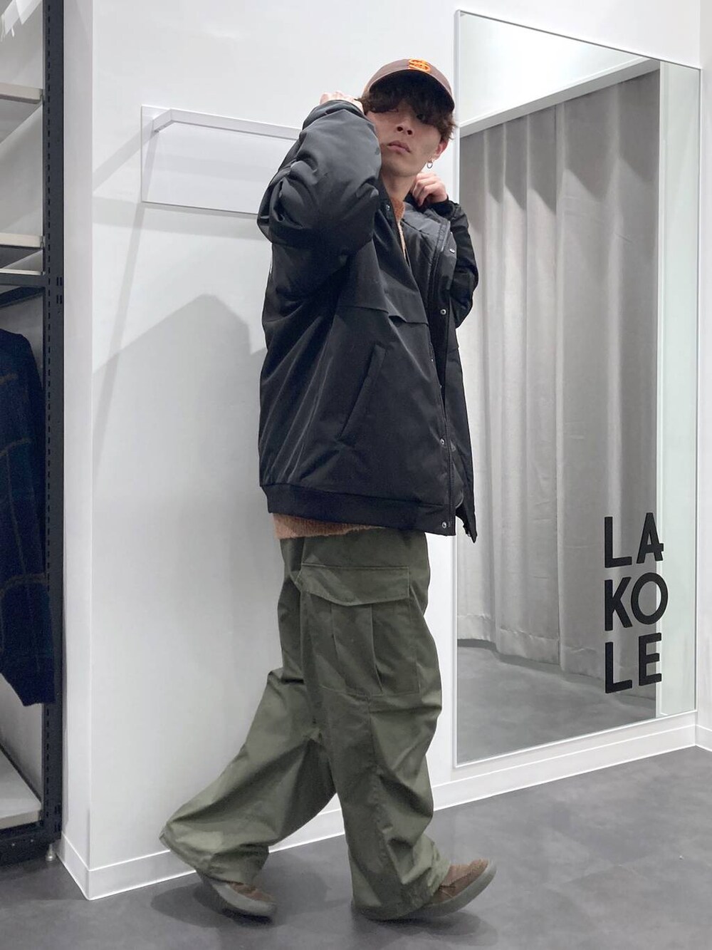 オレンジ系のニット/セーター、ブラック系のショルダーバッグ、ブラック系のブルゾンを着用したメンズの冬コーディネートの3枚目の写真