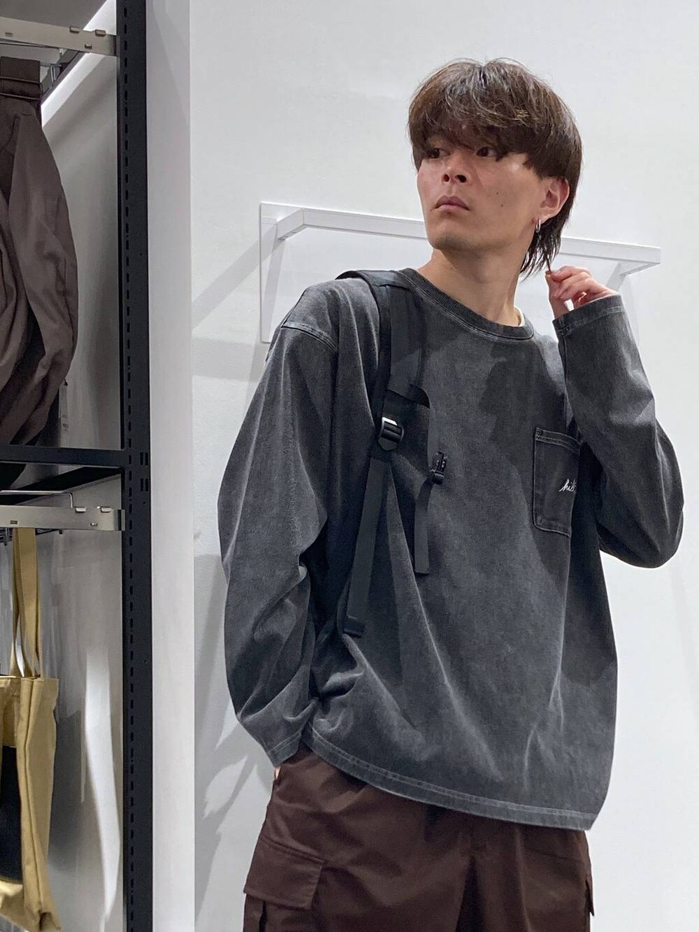 ホワイト系のTシャツ/カットソー、ブラウン系のカーゴパンツ、ブラック系のバックパック/リュックを着用したメンズの夏コーディネートの6枚目の写真