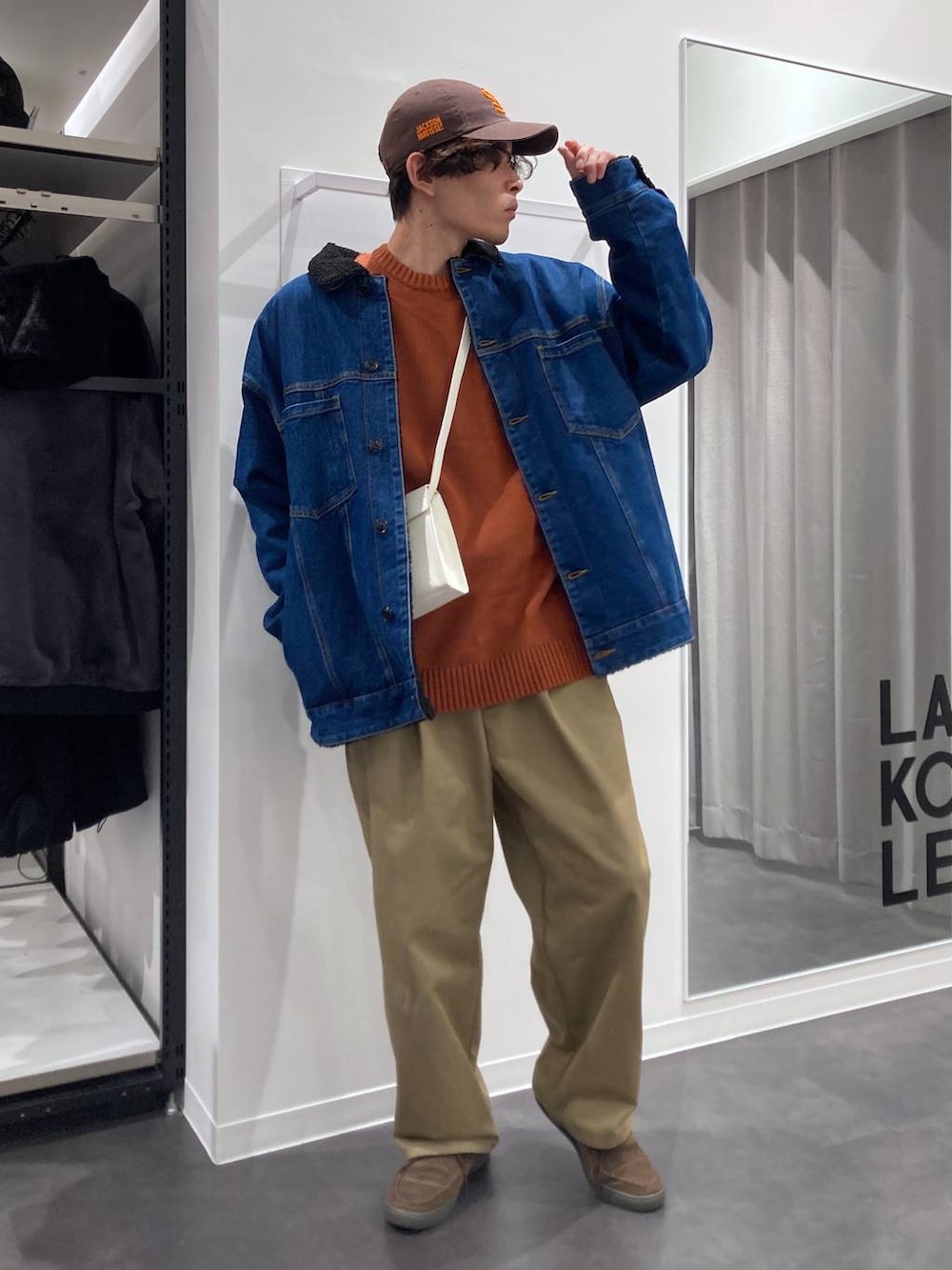 ブルー系のデニムジャケット、ベージュ系のチノパンツ、オレンジ系のニット/セーターを着用したメンズの冬コーディネートの6枚目の写真