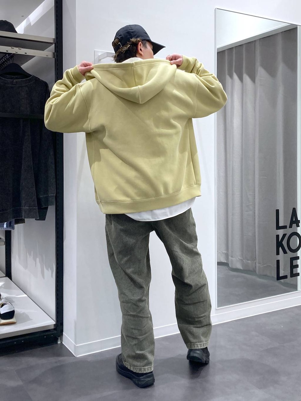 ブラック系のスリッポン、グリーン系のデニムパンツ、イエロー系のパーカーを着用したメンズの冬コーディネートの5枚目の写真