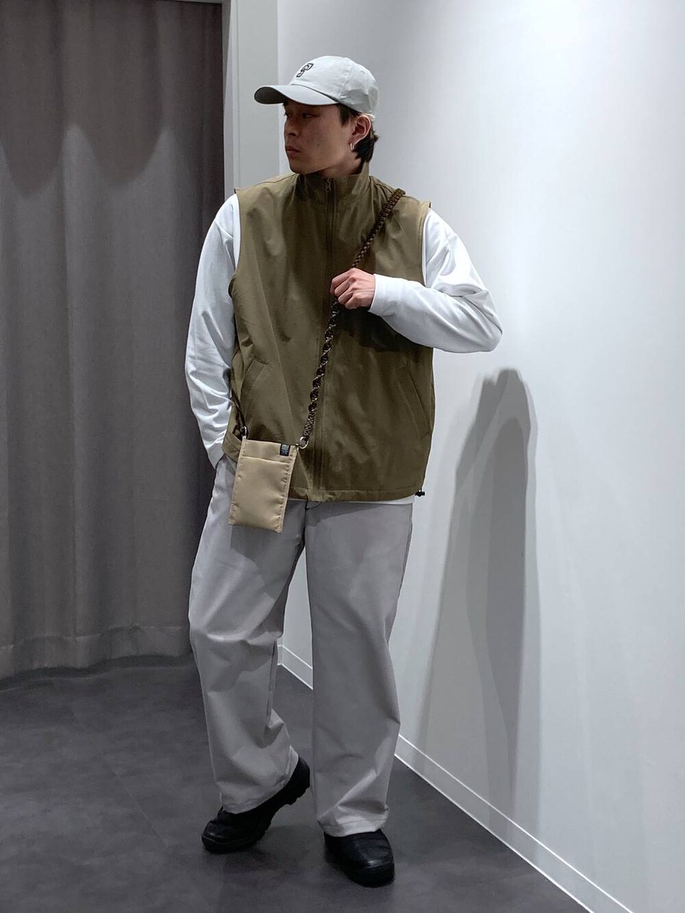 ベージュ系のベスト、グレー系のその他パンツ、ブラック系のスリッポンを着用したメンズの冬コーディネートの5枚目の写真