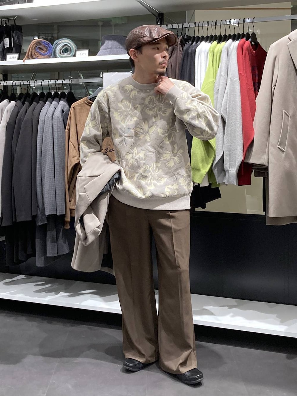 ホワイト系のチェスターコート、ベージュ系のニット/セーター、ブラウン系のその他パンツを着用したメンズの冬コーディネートの5枚目の写真